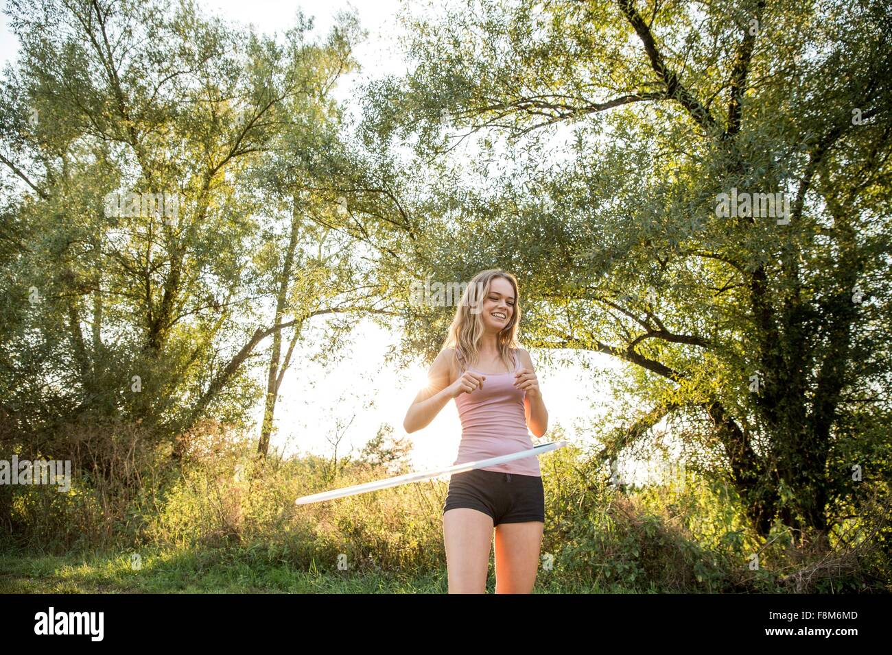 Young girl in rural environment, using hula hoop, smiling Stock Photo