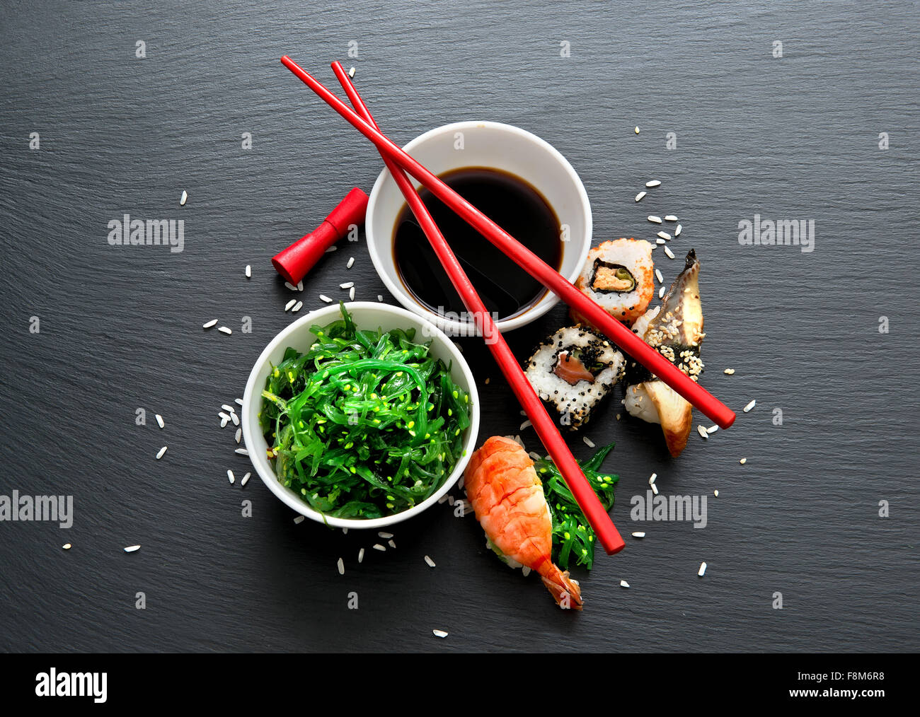 Seaweed salad and sushi on a slate table Stock Photo