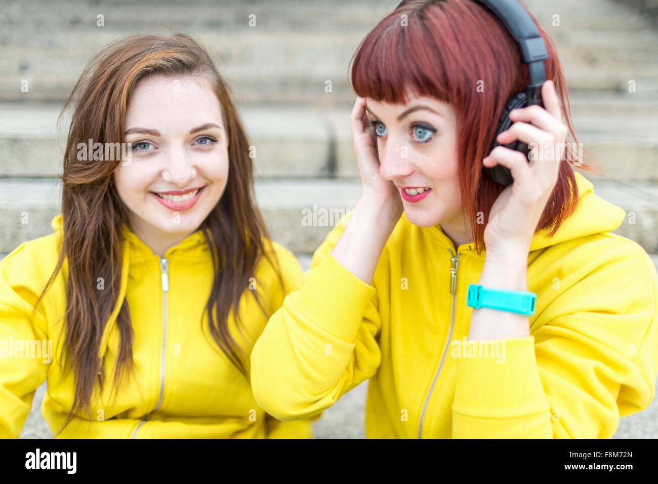 Young women with earphones on steps Stock Photo