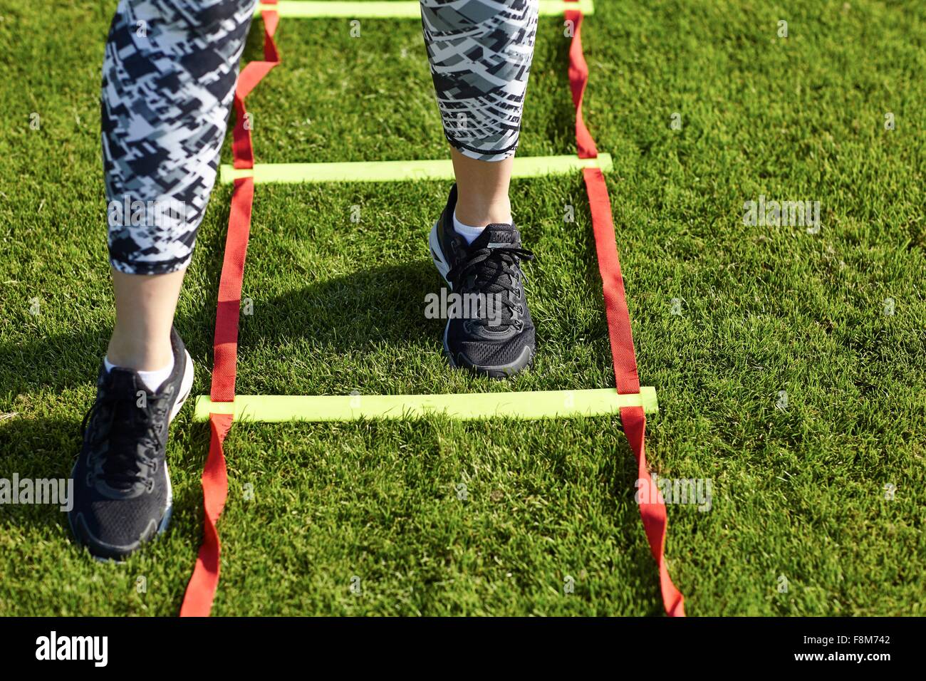 Feet of young woman training on agility ladder Stock Photo