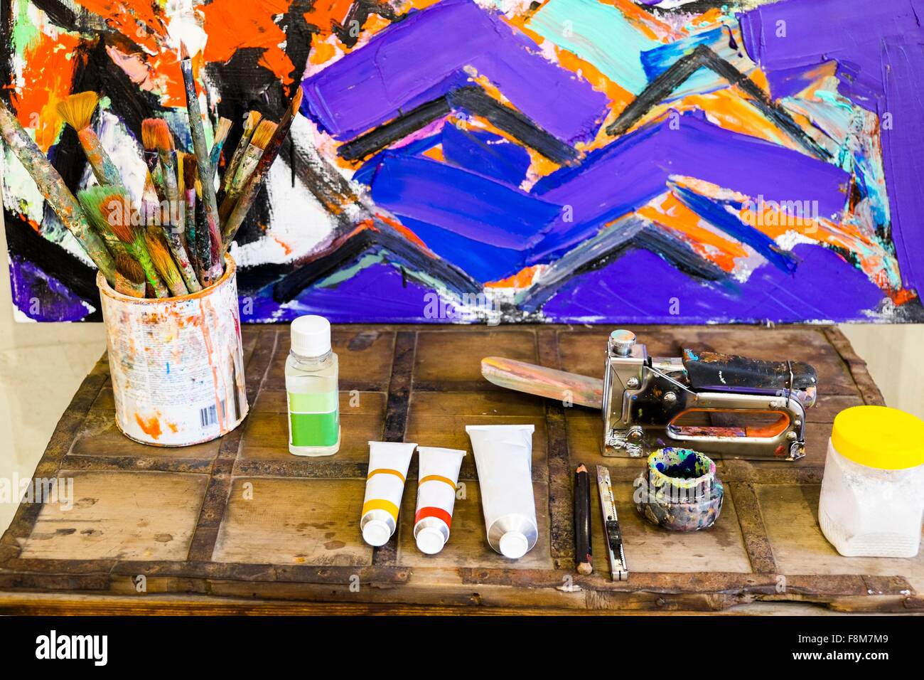 High angle view of art supplies and modern oil painting on wooden trunk Stock Photo
