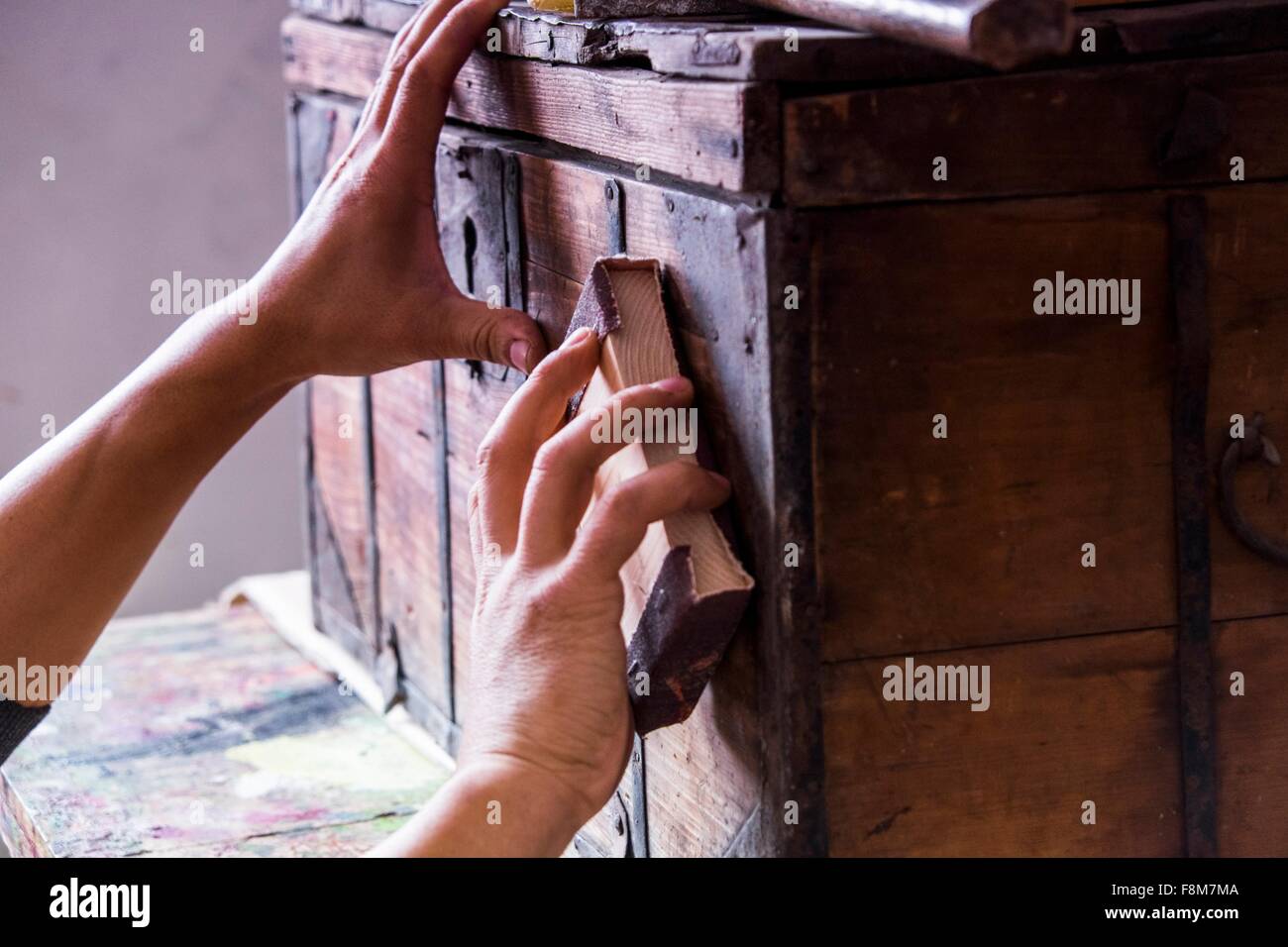 Hands of man sanding wooden trunk suitcase Stock Photo