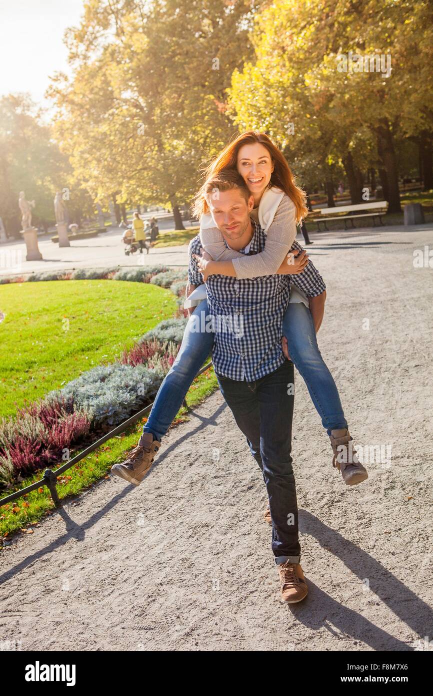 Couple playing piggyback ride in park Stock Photo - Alamy