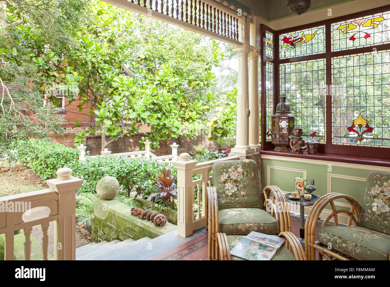 The home of designer Erica Pols. Porch off the dining room leading to the garden. An enclosed space, with windows on three sides, chairs and table under cover, and steps into the garden. Stock Photo