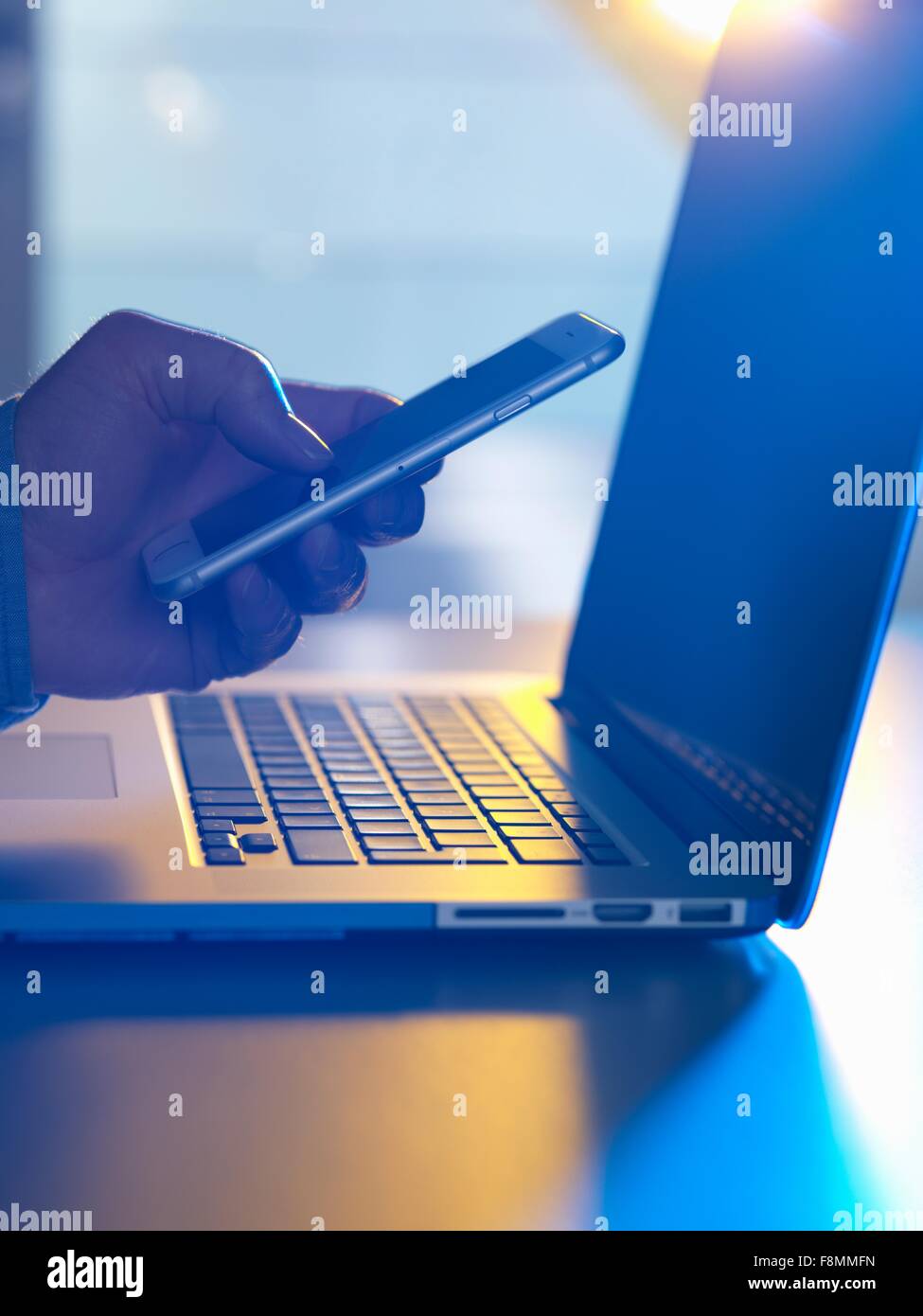 Man texting at laptop computer Stock Photo