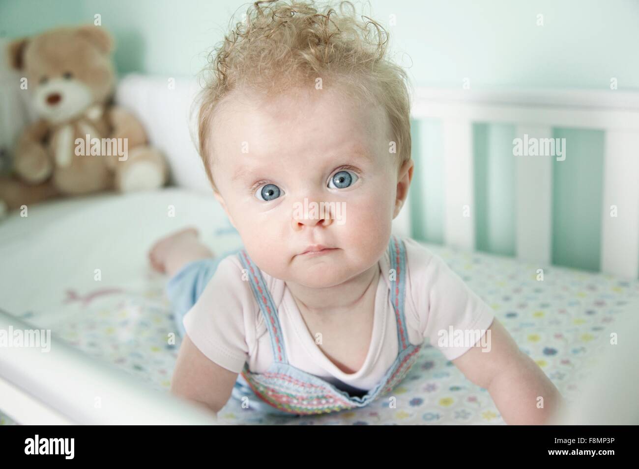 Portrait of baby girl lying in cot Stock Photo