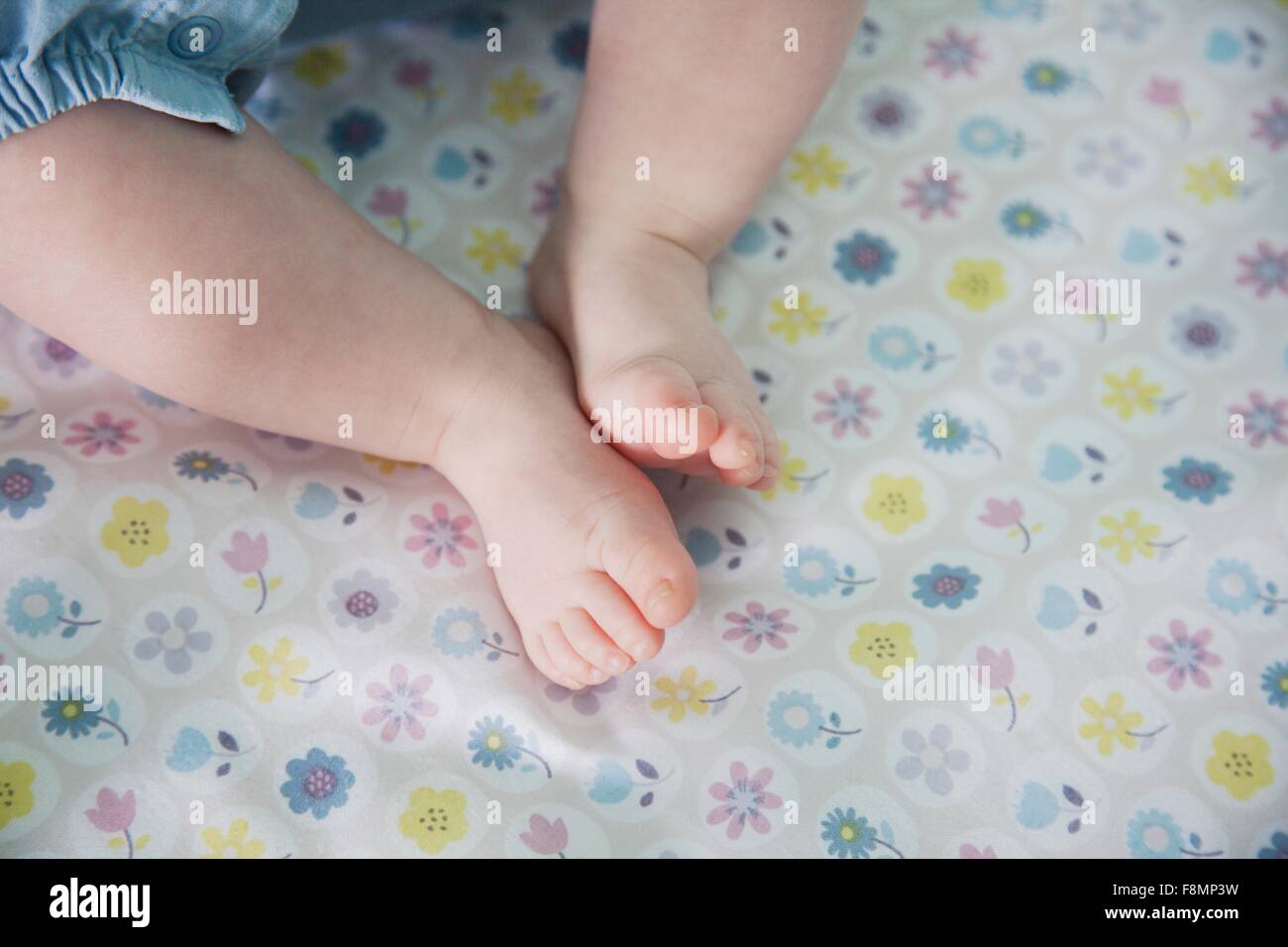 Baby girl lying down, focus on feet Stock Photo