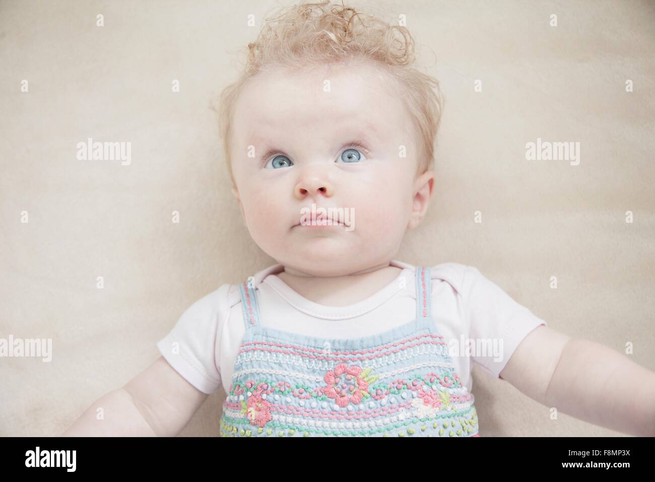 Baby girl lying down, looking away Stock Photo Alamy