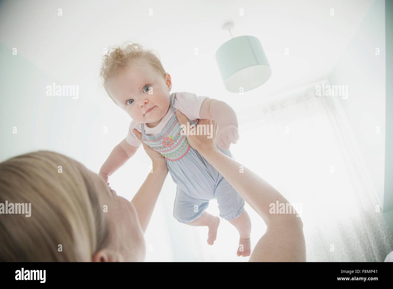 Mother holding baby daughter in air Stock Photo