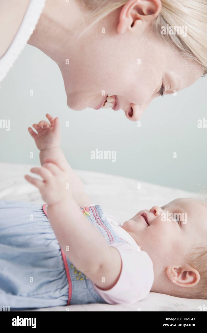 Mother and baby daughter face to face, laughing Stock Photo