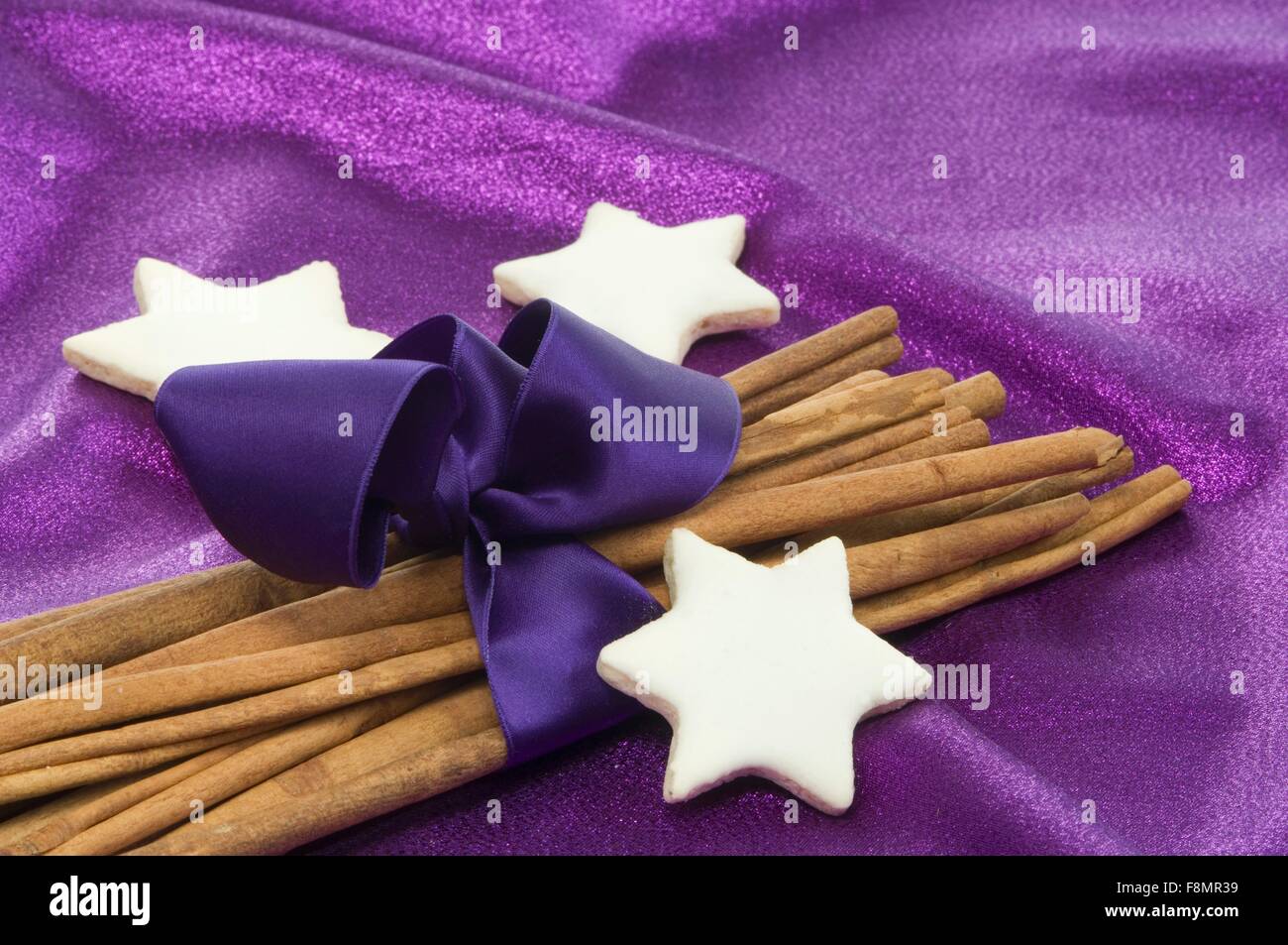 Cinnamon stars with cinnamon sticks wrapped with purple ribbon Stock Photo