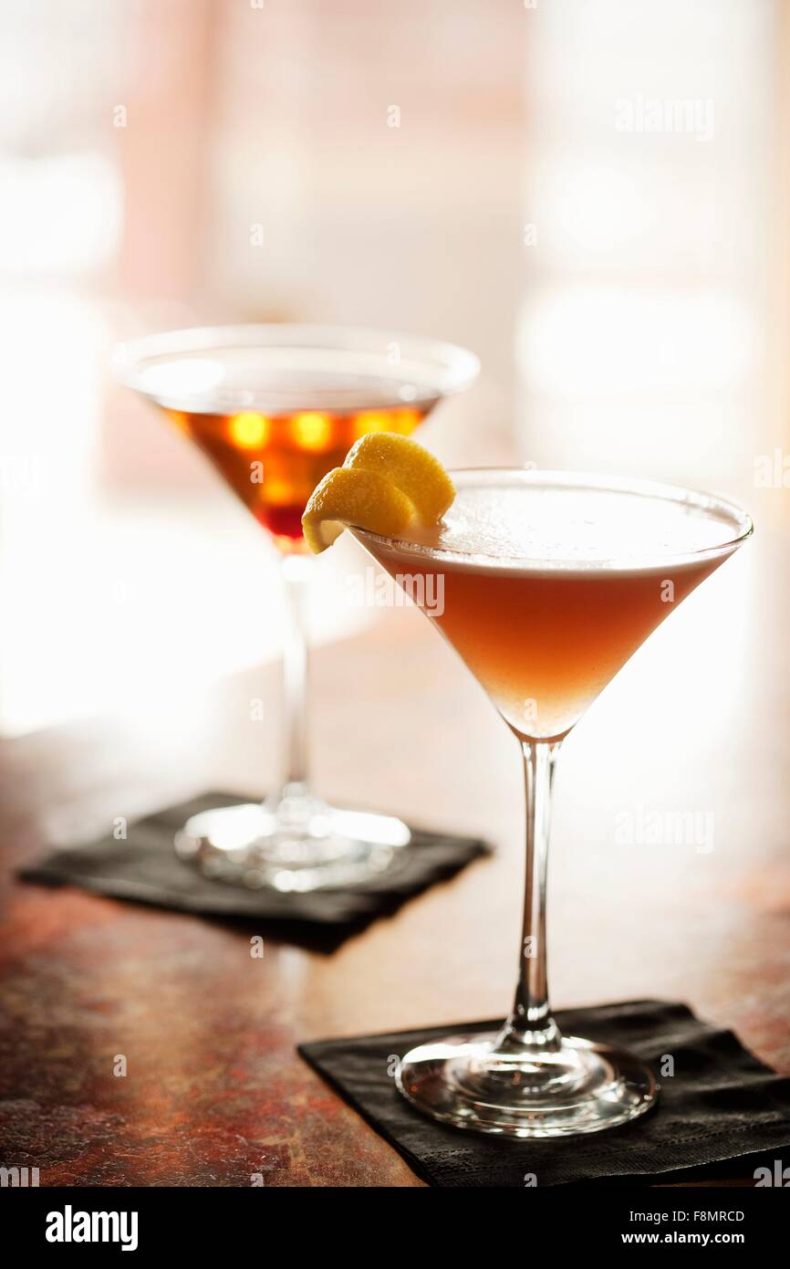 Two Cocktails in Stem Glasses on a Bar (Aviation Cocktail and Manhattan) Stock Photo