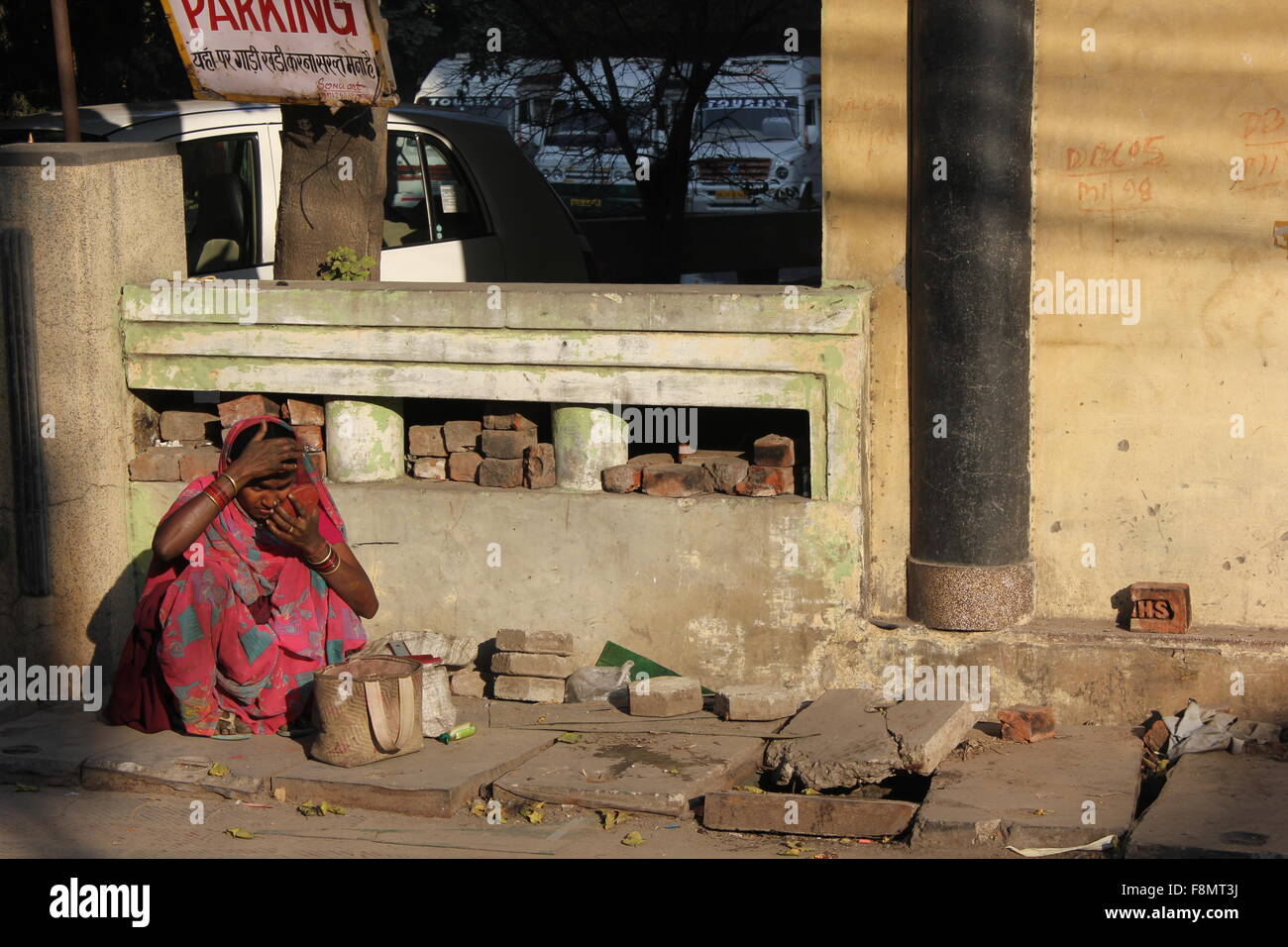 DELHI, DIC 1 2012: Porr Indian woman sit on a ruined street, with anything  around Stock Photo - Alamy