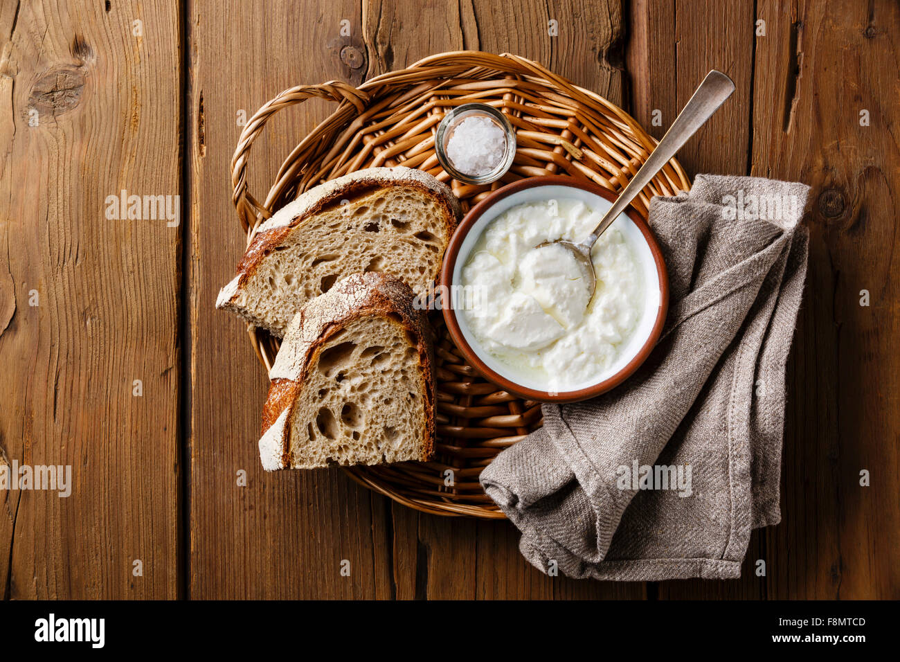 Clabber sour milk and brown rye bread on wicker tray on wooden background Stock Photo