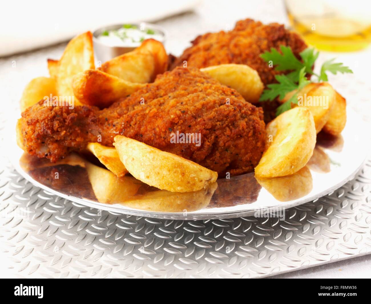 Spicy breaded chicken legs with potato wedges Stock Photo