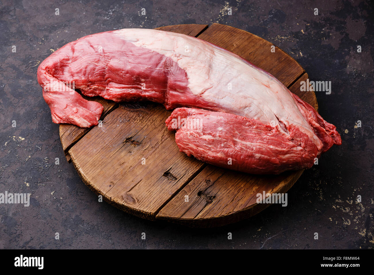 Beef raw fillet tenderloin on cutting board on dark background Stock Photo