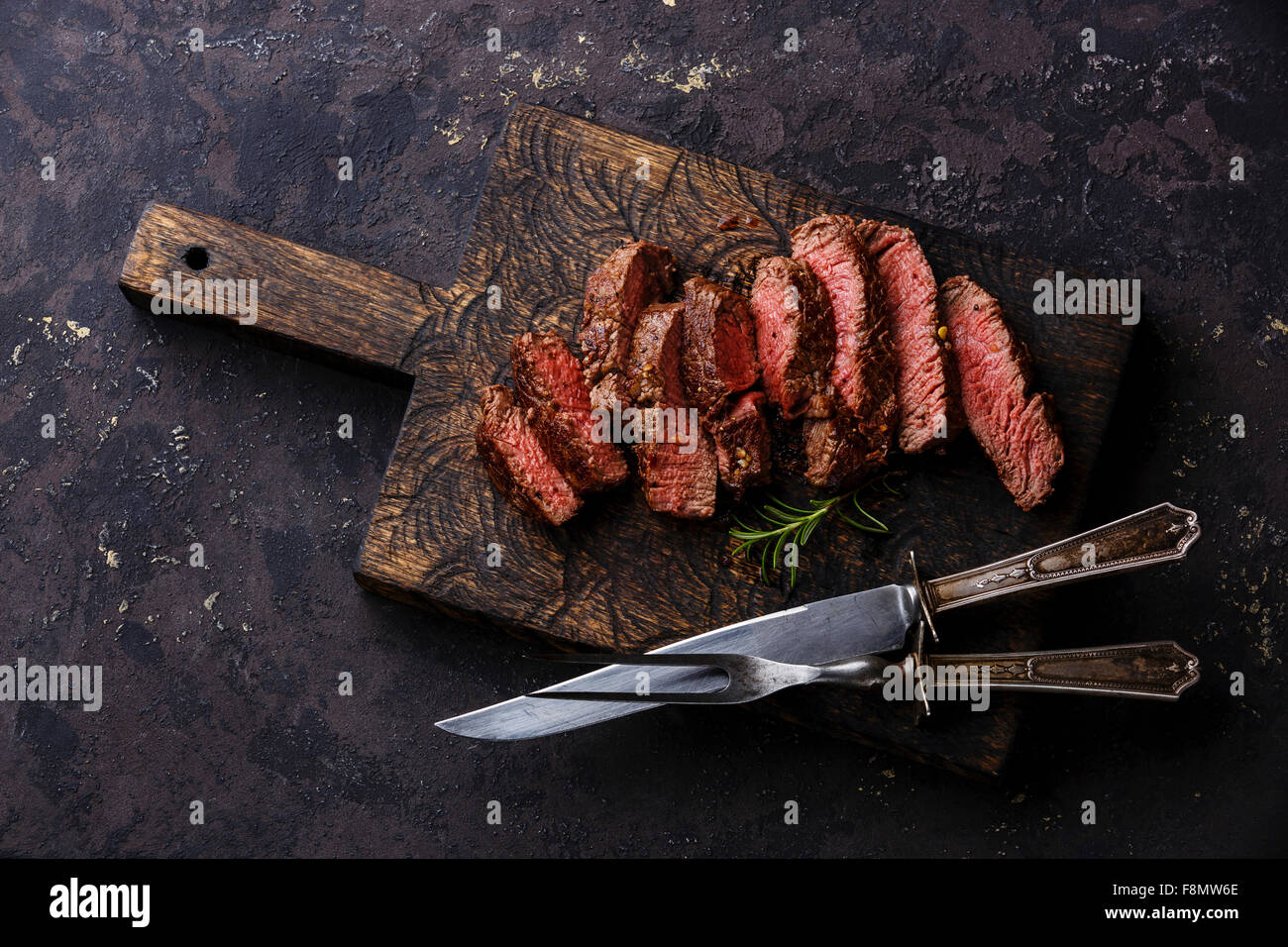 Sliced medium rare grilled Beef steak with knife and fork for meat on