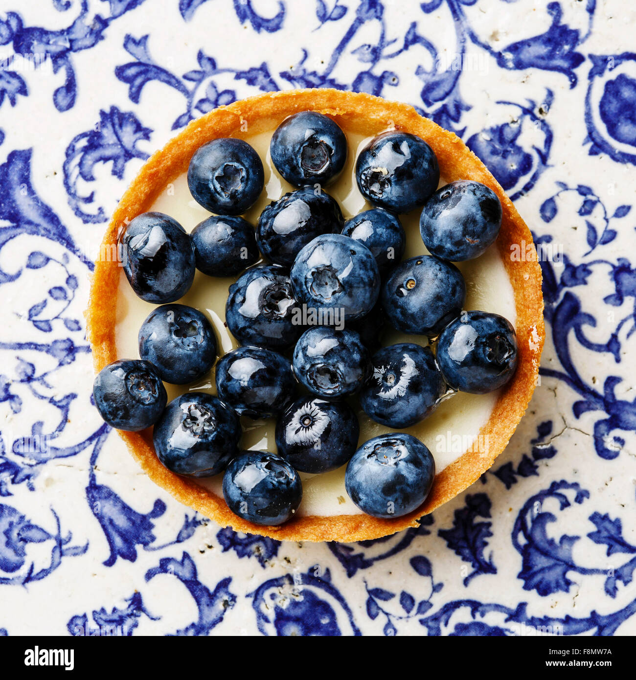Blueberry tart on blue ornament background Stock Photo