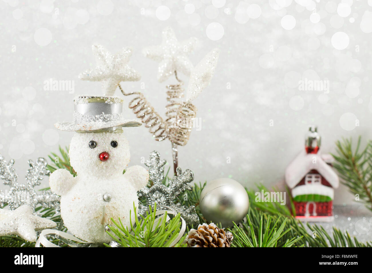 Toy snowman in his imaginary miniature world with shiny winter background Stock Photo