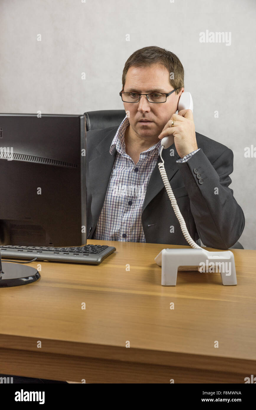 A man working at his computer in the office Stock Photo