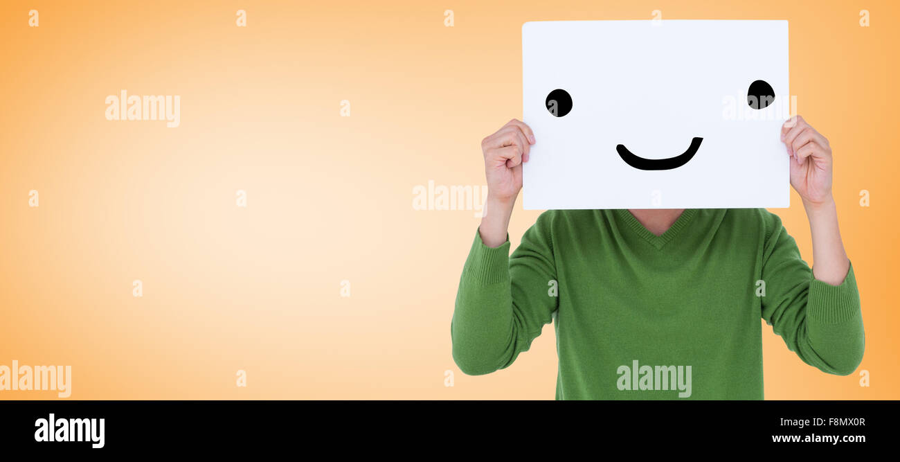 Composite image of man holding blank sign in front of face Stock Photo