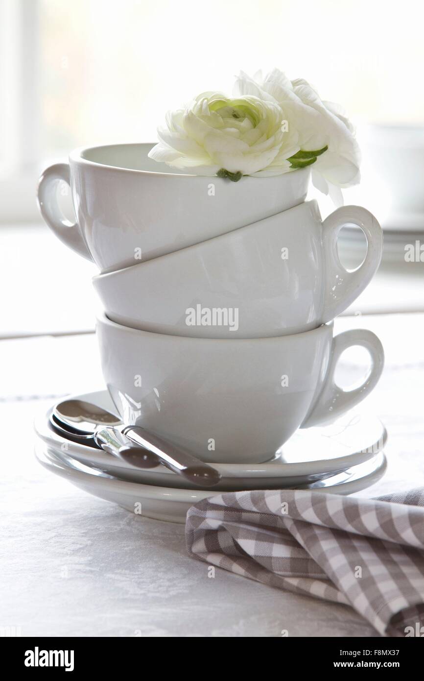 Stacked coffee cups decorated with white flowers Stock Photo