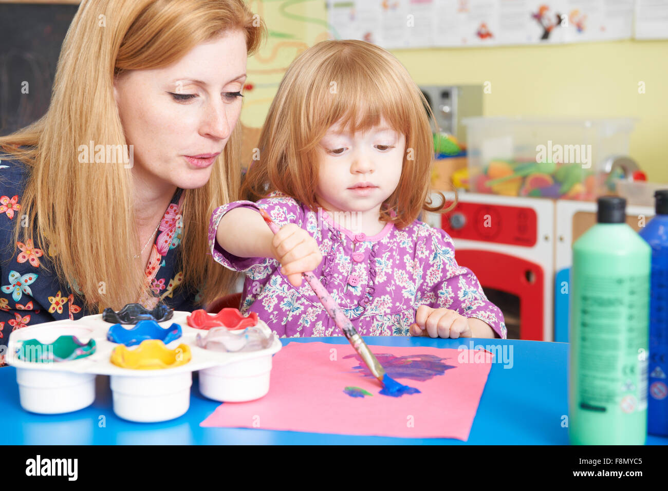 Teacher Helping Pre School Child In Art Class Stock Photo Alamy