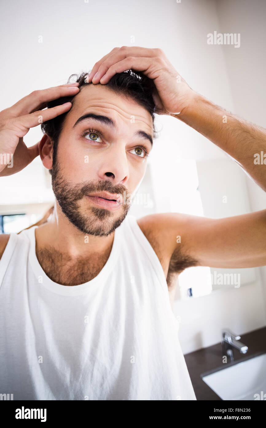 Concentrated man looking at his hair Stock Photo