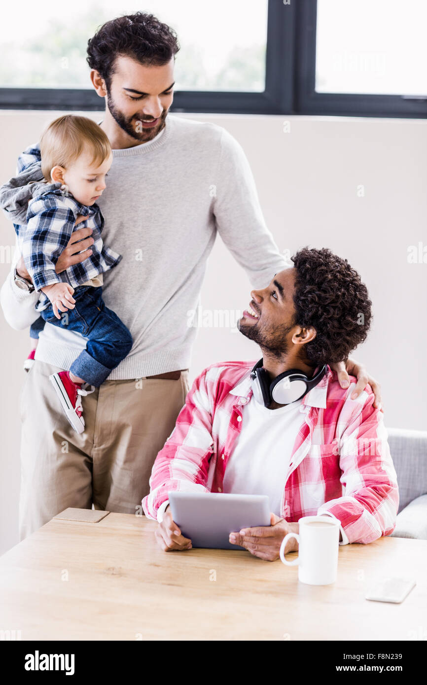 Happy gay couple with child using tablet Stock Photo