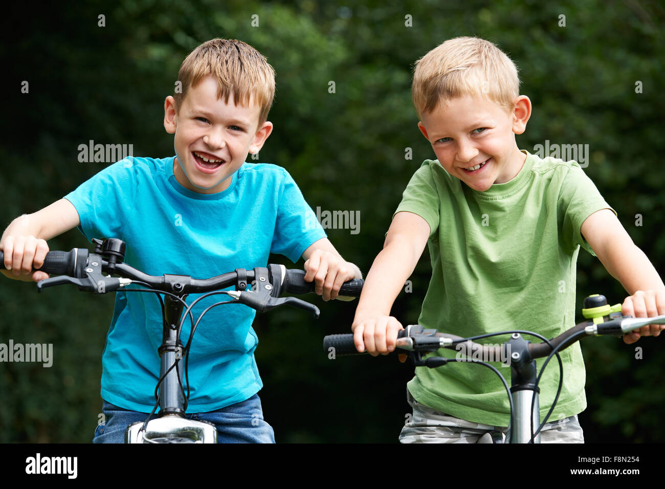 Two Boys Riding Bikes Together Stock Photo