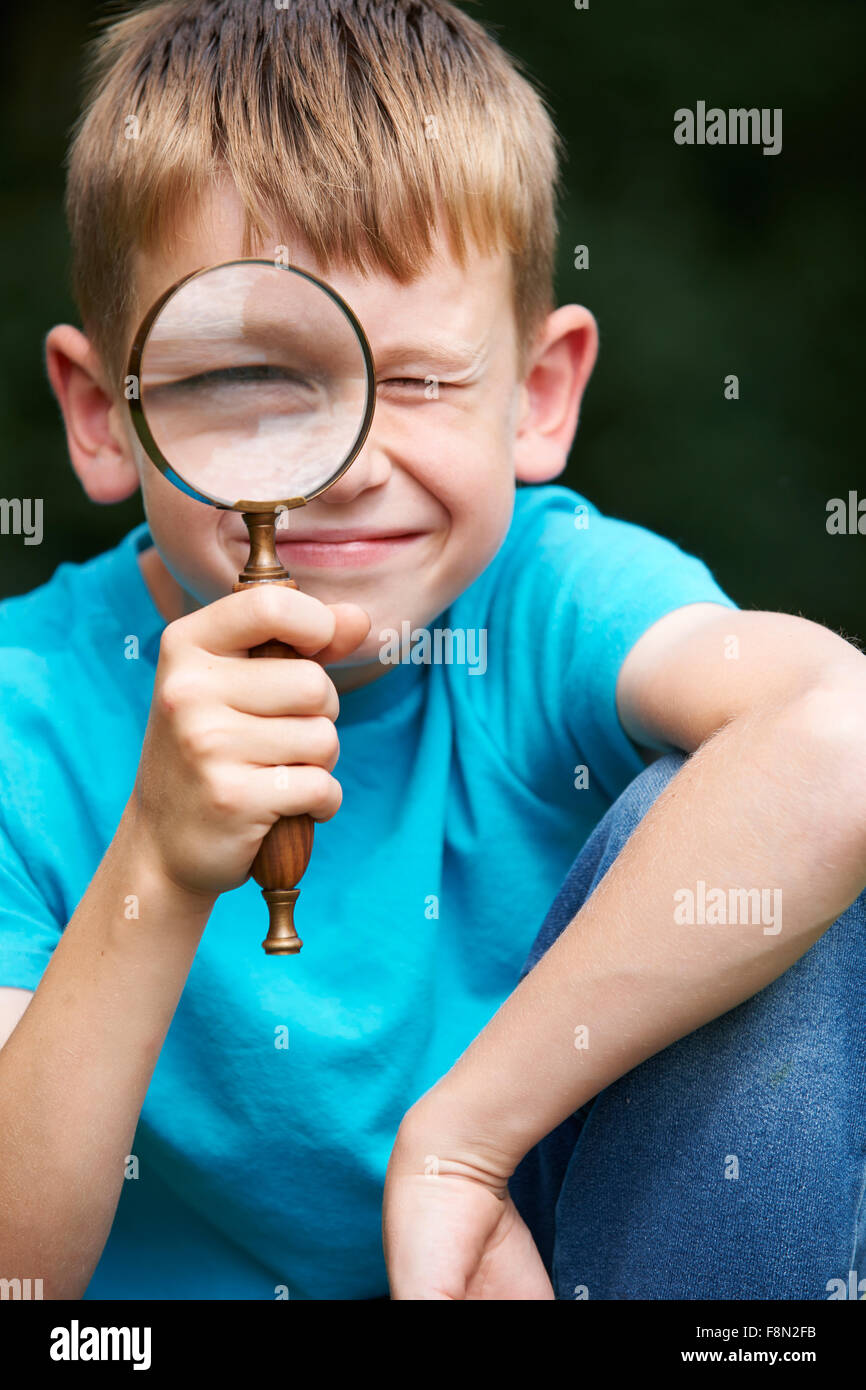 Boy Looking Through Magnifying Glass With Magnified Eye Stock Photo