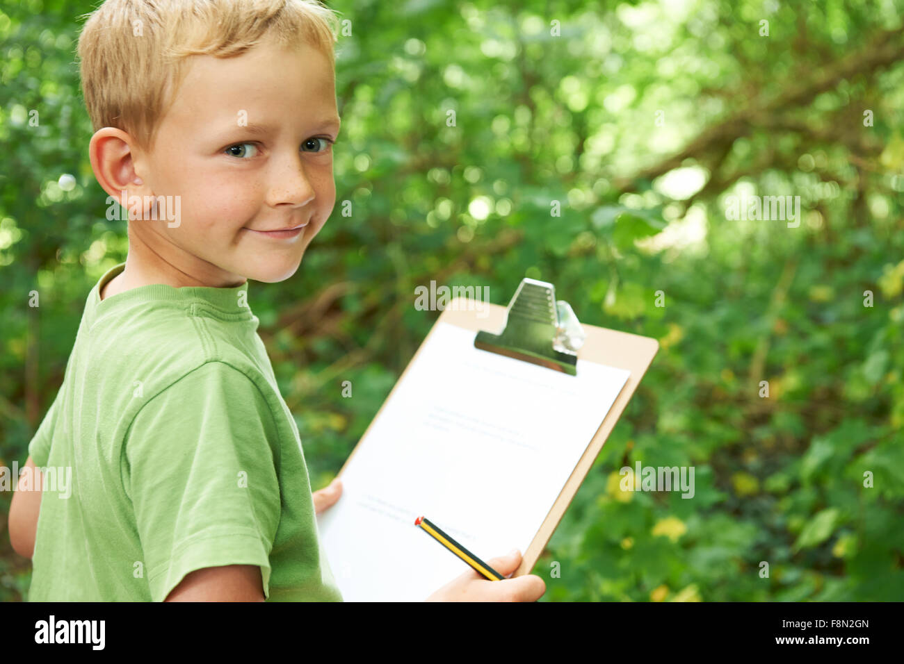 Boy Making Notes On School Nature Field Trip Stock Photo