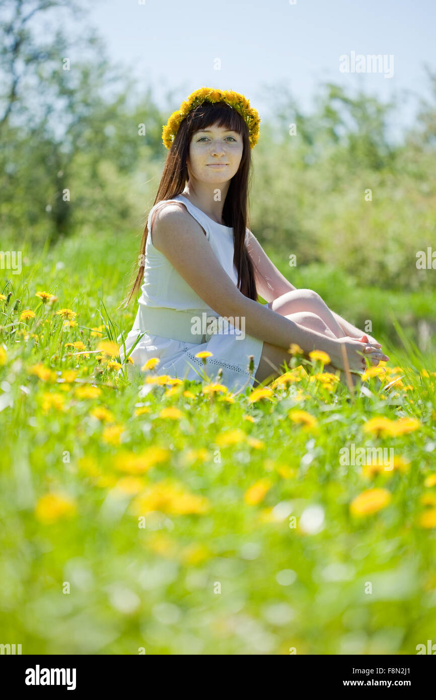 Happy girl sitting outdoor in dandelion meadow Stock Photo - Alamy