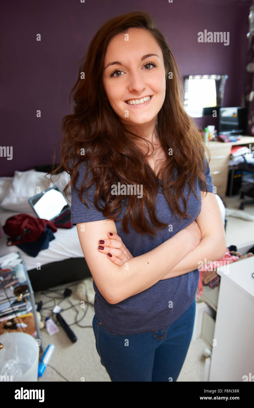 Portrait Of Teenage Girl In Untidy Bedroom Stock Photo