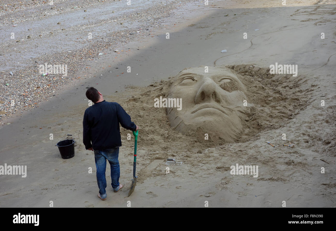 Sand sculpture and artist on shore of River Thames, Southbank, London. Stock Photo