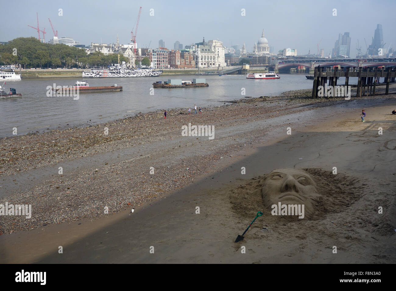 Sand sculpture and artist on shore of River Thames, Southbank, London. Stock Photo