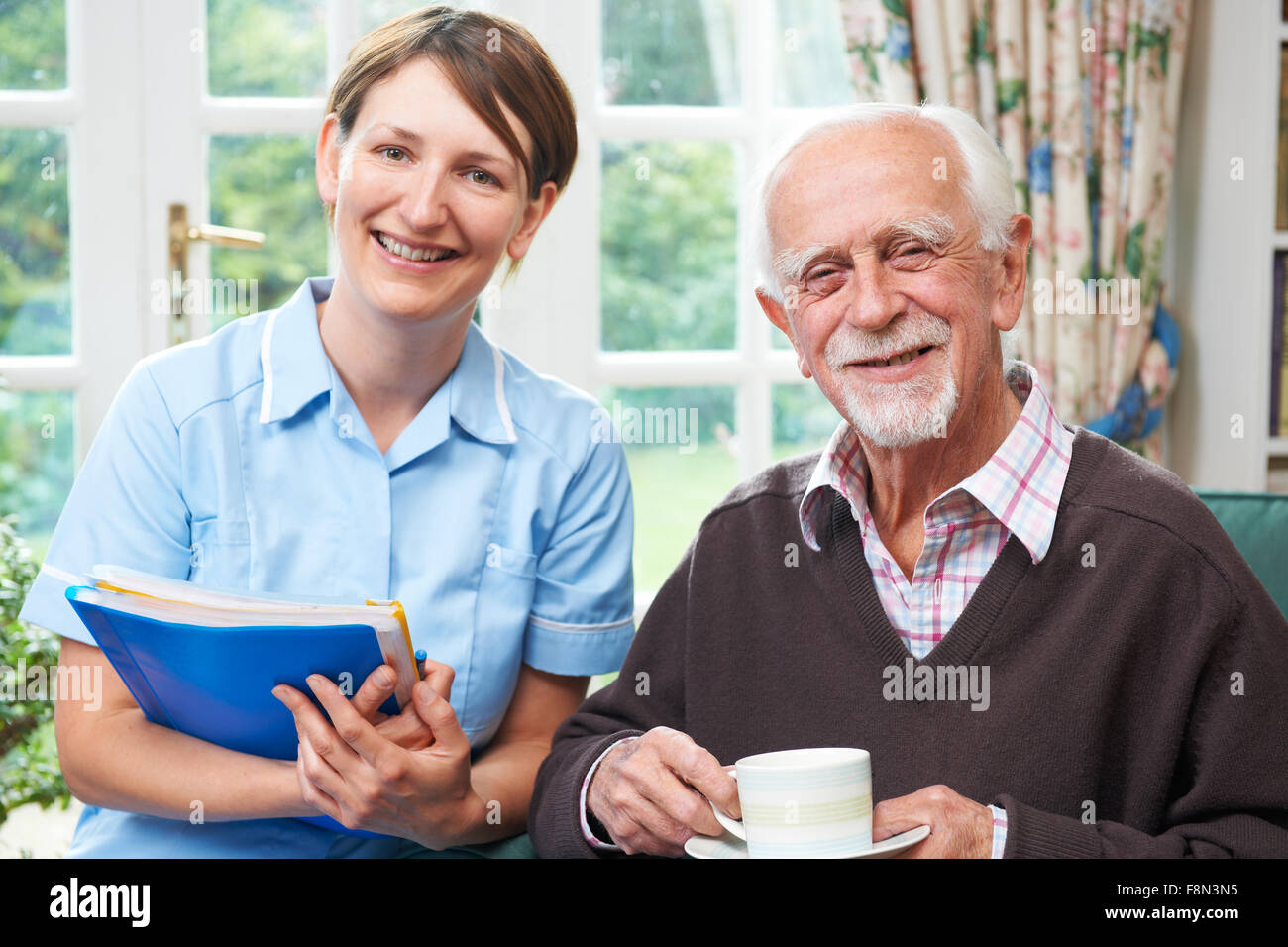 Senior man With Carer At Home Stock Photo