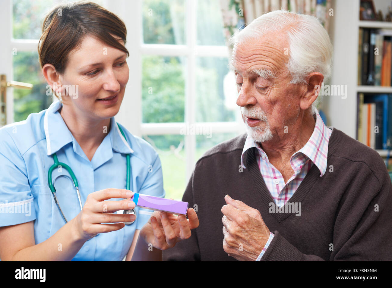 Carer Helping Senior Man With Medication Stock Photo