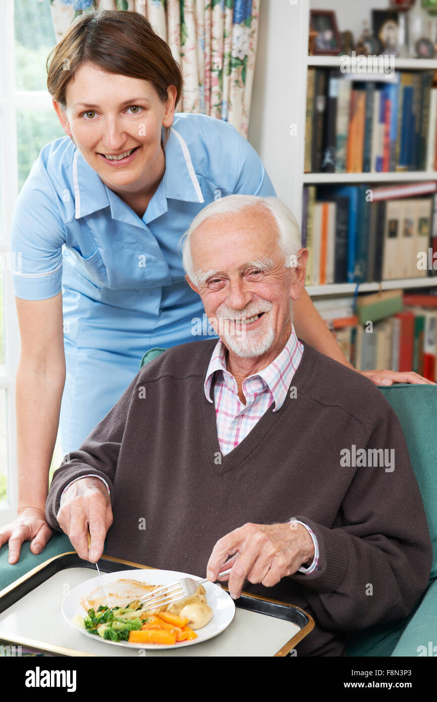 Carer Serving Lunch To Senior Man Stock Photo