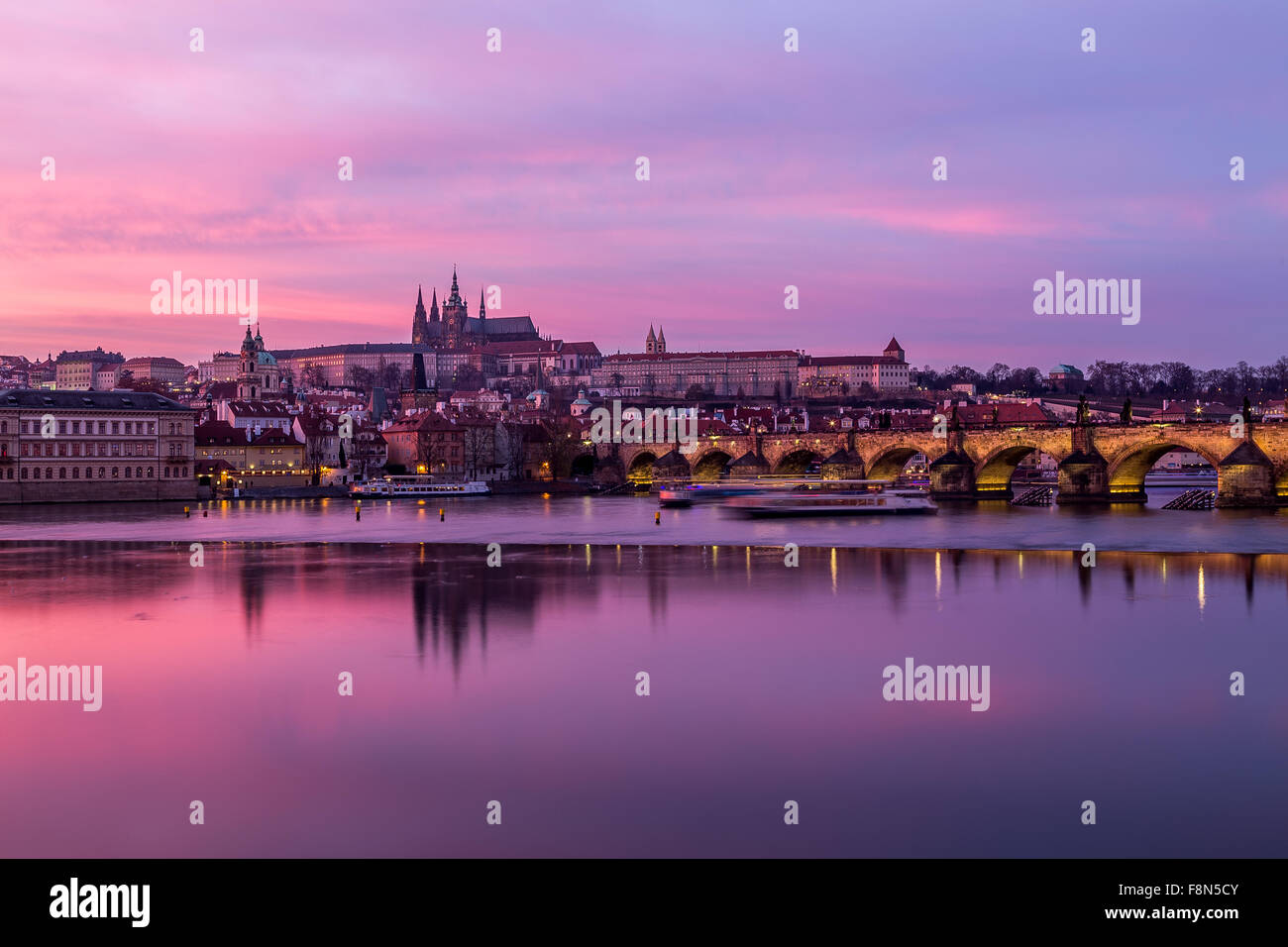 Charles Bridge in Prague, towards the Lesser Quarter and Prague Castle at sunset with a colorful vibrant sky. Stock Photo