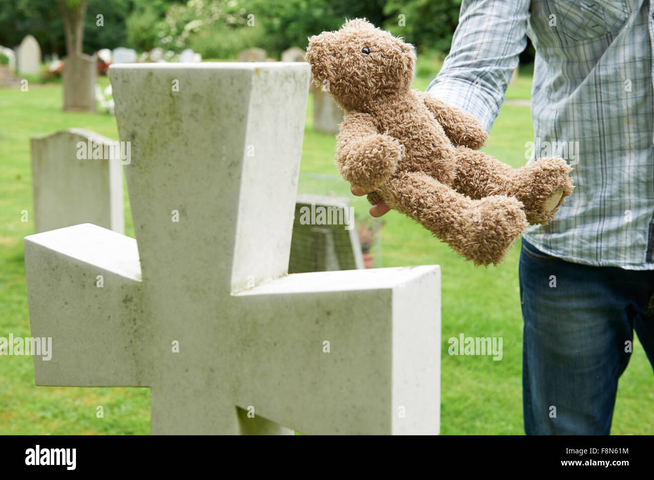 Father Placing Teddy Bear On Child's Grave In Cemetery Stock Photo Alamy