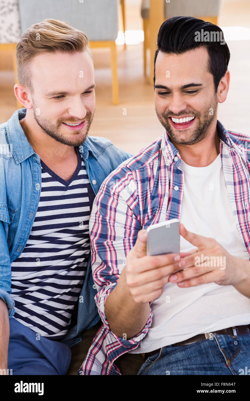 Gay couple relaxing on the couch using phone Stock Photo