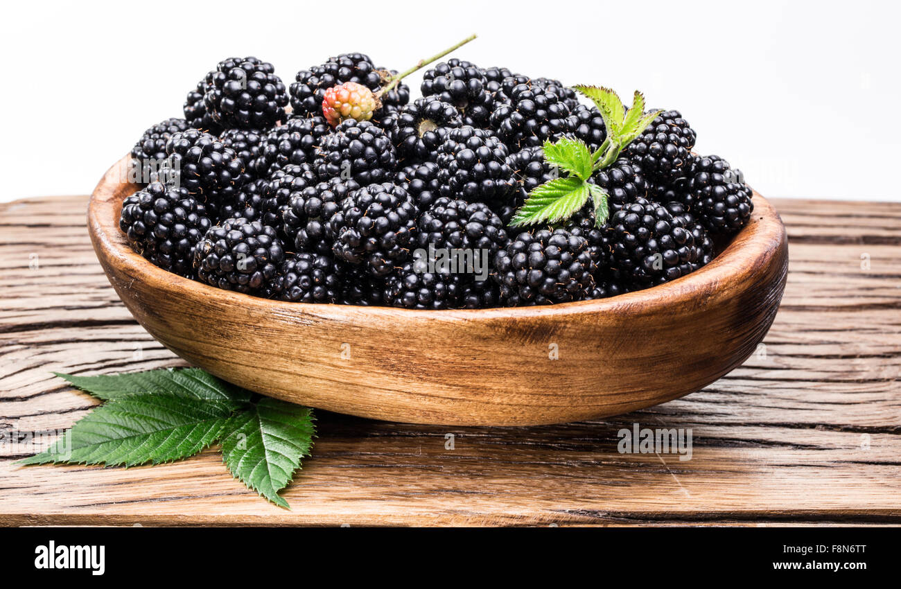 Blackberries in the wooden bowl on the table. File contains clipping paths. Stock Photo