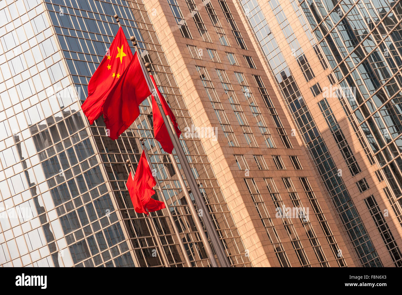 Chinese flags outside reflective glass on building Stock Photo