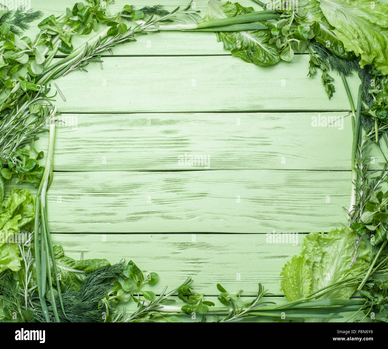 Green herbs on the green wooden background Stock Photo - Alamy