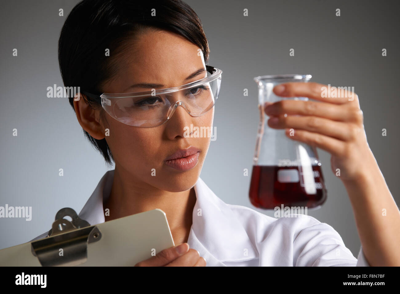 Scientist With Clipboard Examining Beaker Stock Photo Alamy