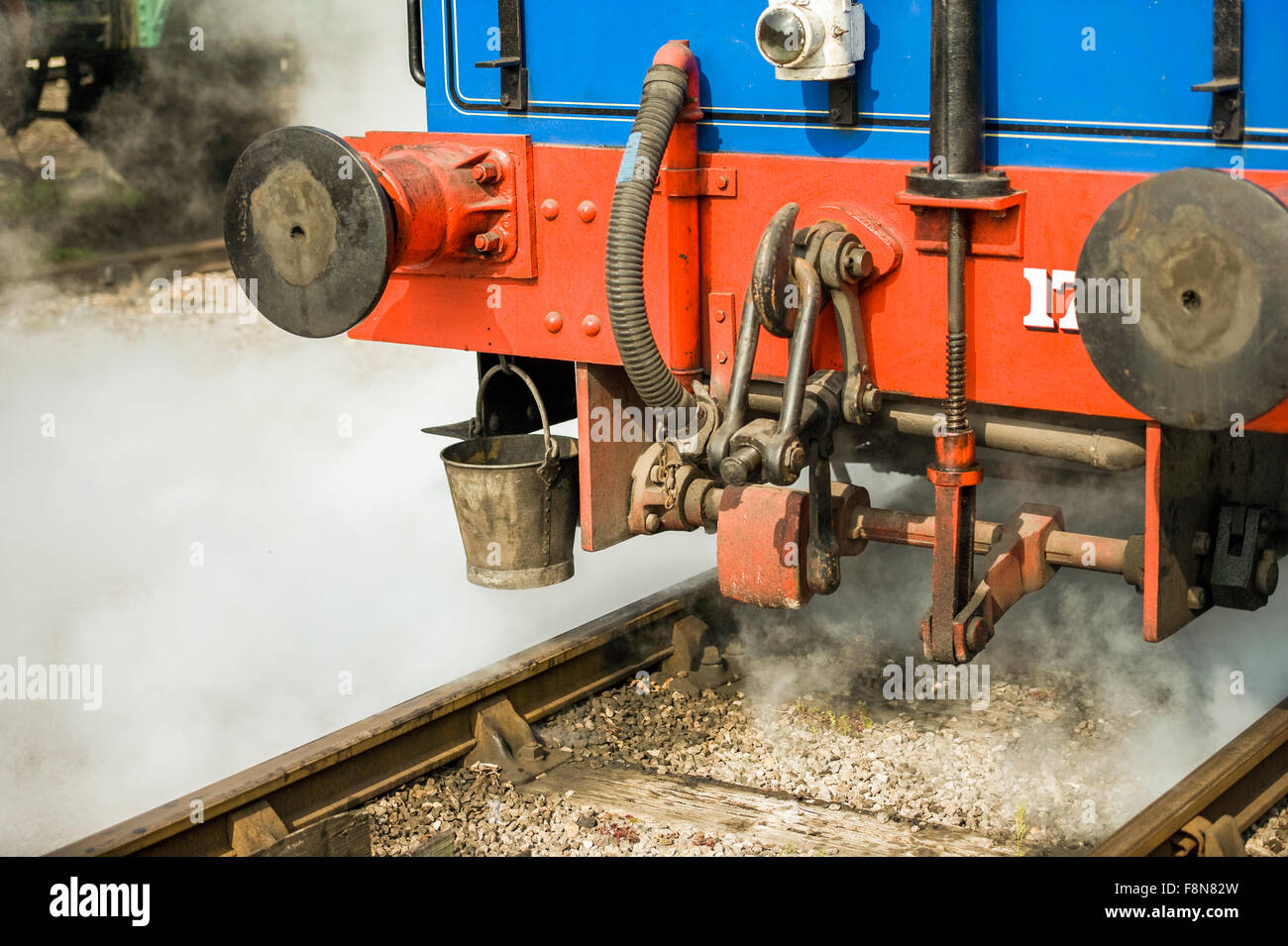 Train detail on railway track with steam Stock Photo