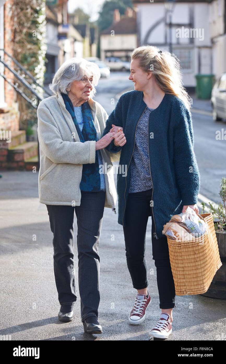 Teenage Girl Helping Senior Woman To Carry Shopping Stock Photo Alamy