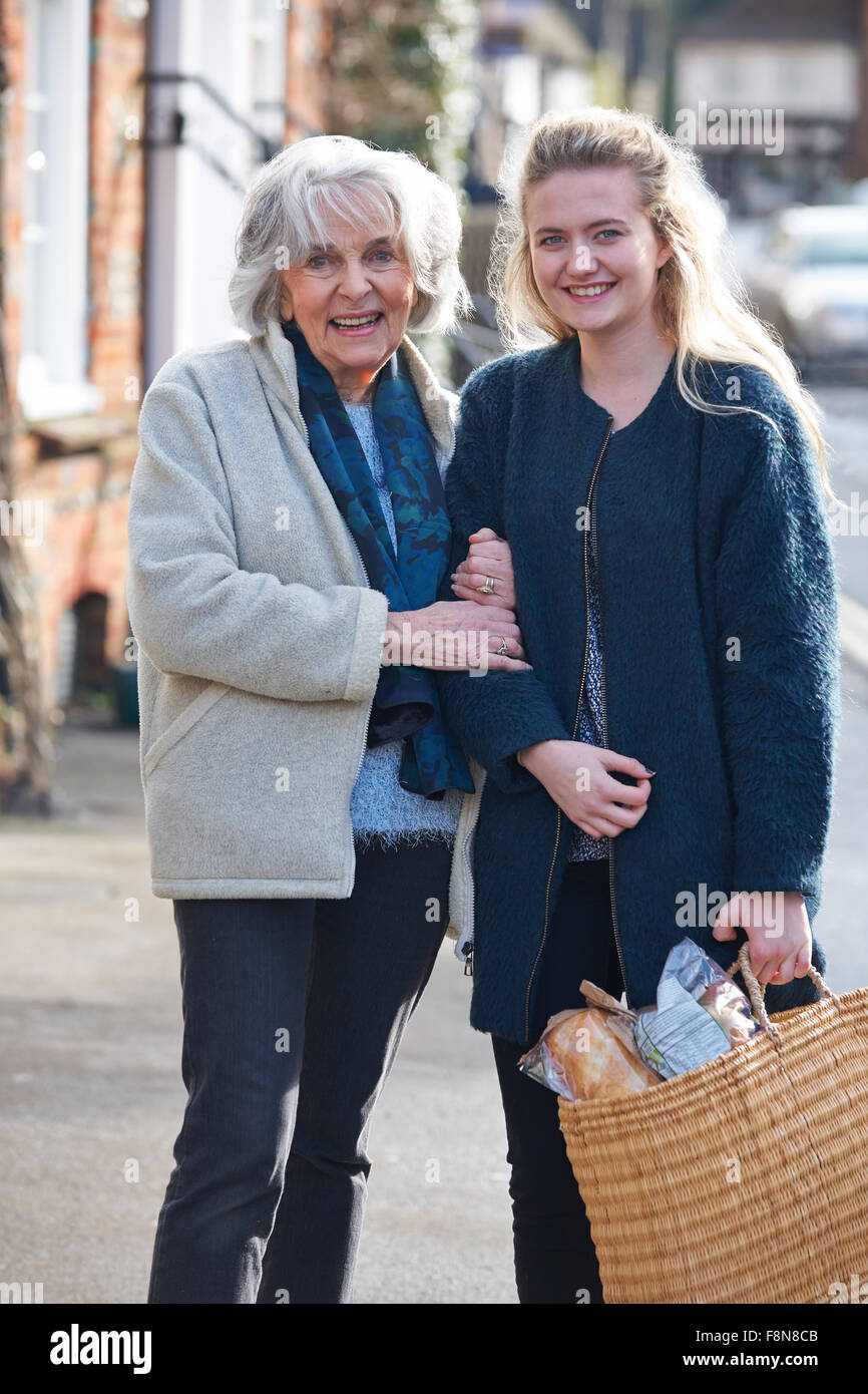 Teenage Girl Helping Senior Woman To Carry Shopping Stock Photo Alamy