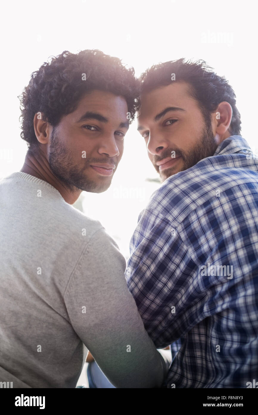 Smiling gay couple looking back at the camera Stock Photo